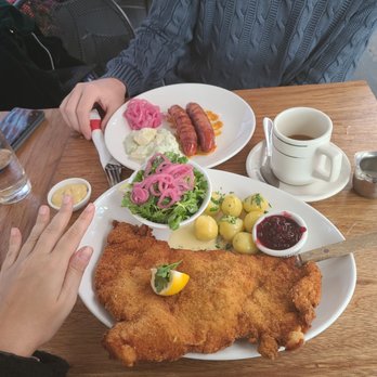 Cafe Katja - Wiener schnitzel (veal) and behind is bernerwurst. - German Near Me - New York, New York Cafe Katja - Wiener schnitzel (veal) and behind is bernerwurst. - German Near Me - New York, New York