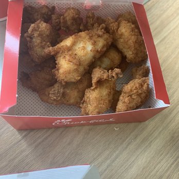 Chick-fil-A - Chick-fil-A- Nuggets - A red Chick-fil-A box contains fried chicken nuggets, placed on a wooden table. The nuggets are golden brown and crispy. - Fast Food Near Me - Hanover, Maryland