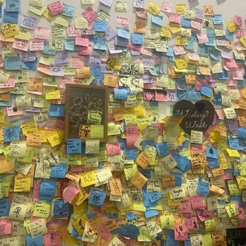 Ming’s Bubble Tea - A densely covered wall features an array of sticky notes in pink, yellow, blue, green, and other colors, each with handwritten messages, drawings, and doodles. The notes include personal notes, sketches, and decorative elements. A blackboard-style sign reads 'Thinking Wall,' and there are framed pictures and signs on the wall, indicating a space for sharing thoughts and messages. - Bubble Tea Near Me - Hudson, Ohio