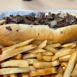 Aromas - Cheesesteak with fried onions and a side of fries.