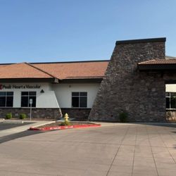 Peak Heart & Vascular - Exterior of Peak Heart & Vascular clinic in Surprise, Arizona, featuring a modern single-story building with stone façade and red-tile roof.