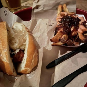 Wursthaus - Bratwurst on a roll with sauerkraut and onions, and fries with caramelized onions. - Pubs Near Me - Santa Ana, California Wursthaus - Bratwurst on a roll with sauerkraut and onions, and fries with caramelized onions. - Pubs Near Me - Santa Ana, California