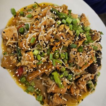 Public House Eatery - Stir fry - A stir fry with tofu, bean sprouts, green onions, and mixed vegetables, garnished with sesame seeds, served on a white plate. - Pizza Near Me - Gorham, New Hampshire