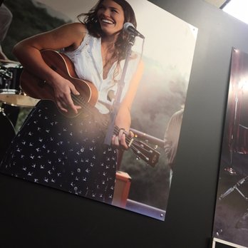 Guitar Center Lessons - Poster of happy person playing guitar in waiting area - Musical Instruments & Teachers Near Me - Rancho Cucamonga, California