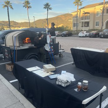 Inferno Woodfired Kitchen - a man cooking a pizza - Food Trucks Near Me