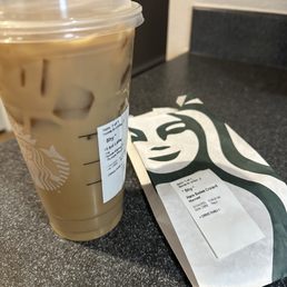 a cup of iced coffee next to a bag of coffee a cup of iced coffee next to a bag of coffee