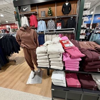 DICK'S Sporting Goods - Women's clothing - Women's hoodies and sweatpants are arranged on tables and mannequins in a sporting goods store, with sale signs visible. - Sports Wear Near Me - Monaca, Pennsylvania