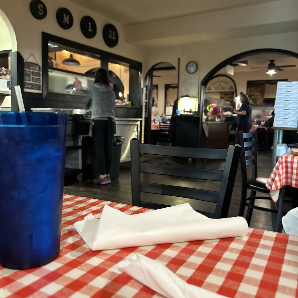 a table in a restaurant with a red and white checkered tablecloth a table in a restaurant with a red and white checkered tablecloth