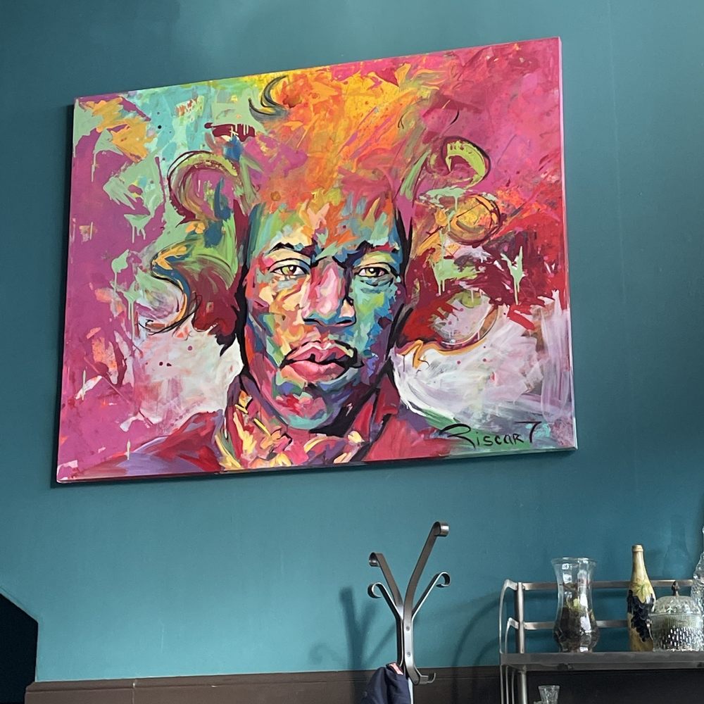 a painting of a man's face on a blue wall a painting of a man's face on a blue wall