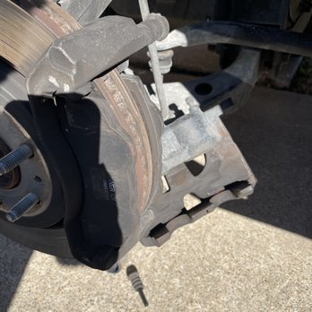 Auto Clinique - you can see where the brake pads on the front side and the backside both have bunny ears the front side should be flat with no bunny ears - Auto Repair Near Me - Dallas, Texas
