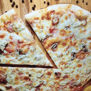 Val's Pizza - a sliced pizza on a cutting board - Pizza Near Me - North Vancouver, British Columbia
