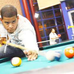UMass Lowell - Campus Recreation Center - Student playing pool.