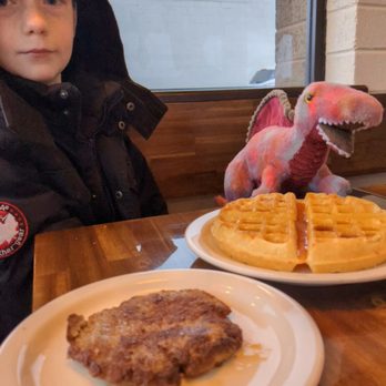 Betty's Cafe - a child sitting at a table with waffles and a stuffed dinosaur - Breakfast & Brunch Near Me - Vernal, Utah Betty's Cafe - a child sitting at a table with waffles and a stuffed dinosaur - Breakfast & Brunch Near Me - Vernal, Utah