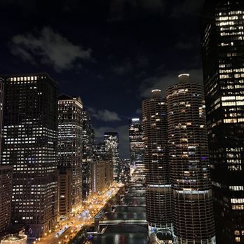 LH Rooftop - The view - Night view of Chicago's downtown with tall buildings, lit windows, and the Chicago River running through the city. - Cocktail Bars Near Me - Chicago, Illinois