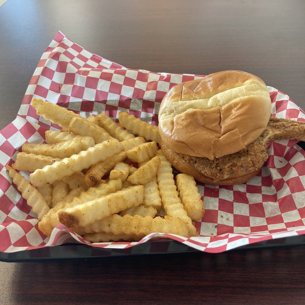 Bone in pork chop sandwich with seasoned fries. Bone in pork chop sandwich with seasoned fries.