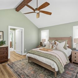 The Dan Company - Remodeled bedroom with vaulted ceiling, wood beam, and fresh finishes by The Dan Company. Photo: Tnhometour