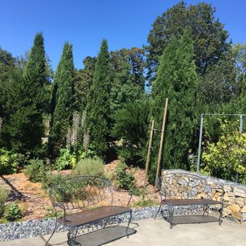 Northwest Wine Academy - a view of a garden with a stone wall and benches - Wineries Near Me - Seattle, Washington