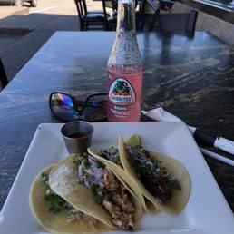 a plate of tacos and a bottle of soda