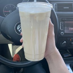 a hand holding a drink in a car
