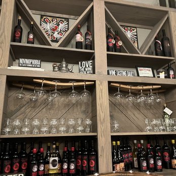 Four Twelve Project - a shelf of wine bottles and glasses - New American Near Me - Coraopolis, Pennsylvania