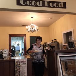 a woman standing behind a counter a woman standing behind a counter