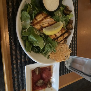 The Caroline - Caesar salad with salmon and a side of stewed tomatoes. Delicious! - American Near Me - Troy, Ohio