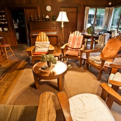 Colby House - This living room photo shows the piano, chairs gathered around the fireplace, and dining area.