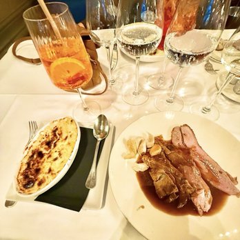 Le Train Bleu - Roast leg of lamb with whole roasted garlic cloves and potato gratin dauphinois side dish - French Near Me - Paris, 75 Le Train Bleu - Roast leg of lamb with whole roasted garlic cloves and potato gratin dauphinois side dish - French Near Me - Paris, 75