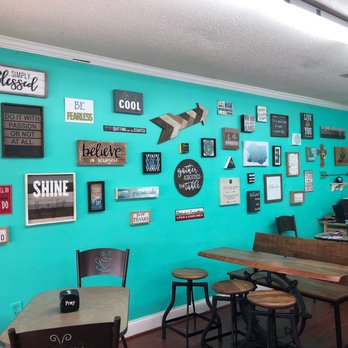 Arrow Nutrition - a turquoise wall with a variety of signs on it - Juice Bars & Smoothies Near Me - Clinton, Mississippi