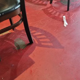 a dirty floor with chairs and a table in the background a dirty floor with chairs and a table in the background