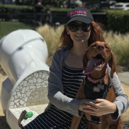 Wife and dog on one of the benches outside the fenced in area.