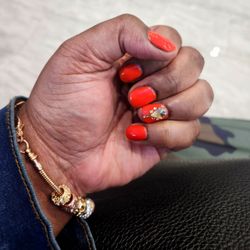 Crystal Nails And Spa - Manicure with orange gel color nail polish.