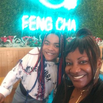 Feng Cha - Two women pose for a selfie in front of a neon sign that reads 'FENG CHA' at Feng Cha in Grapevine, TX, with a decorative background. - Coffee & Tea Near Me - Grapevine, Texas
