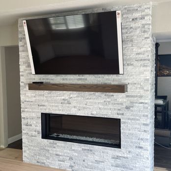 Ruben’s Crew Construction - a flat screen tv mounted on a brick fireplace - General Contractors Near Me