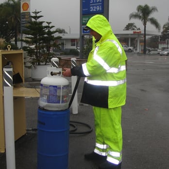 Fairview Chevron Station - a man in a yellow rain suit filling up a tank of water - Gas Stations Near Me - Goleta, California Fairview Chevron Station - a man in a yellow rain suit filling up a tank of water - Gas Stations Near Me - Goleta, California