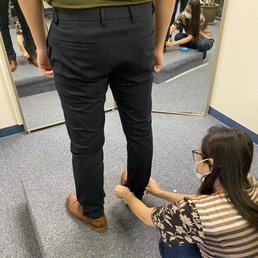 The owner taking measurements for a pants hemming. The owner taking measurements for a pants hemming.