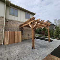 Delong Landscaping - Stamped concete patio with a Pergola and privacy fence.