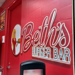 a red wall with a sign that says beth's burger bar a red wall with a sign that says beth's burger bar