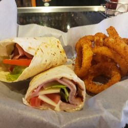 Valley Grill Sports Bar - Club Wrap with a side of onion rings.