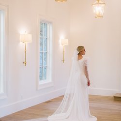 Moments Made Bridal - Aniston gown featuring a puff sleeve that tightens at forearm with beautiful buttons. Simple crepe fitted gown with a pearl bow veil.