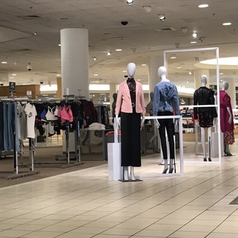 Macy's - Mannequins dressed in casual and formal outfits are arranged in a department store setting with clothing racks in the background. - Department Stores Near Me - Ann Arbor, Michigan