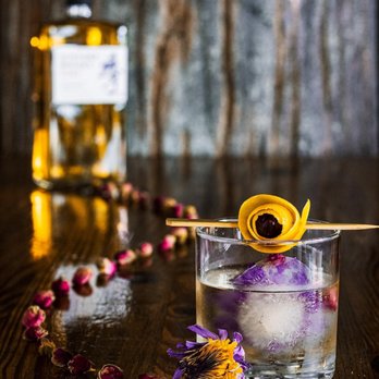 Iron Oak Post - a glass of alcohol with a flower garnish - Bars Near Me - Melbourne, Florida Iron Oak Post - a glass of alcohol with a flower garnish - Bars Near Me - Melbourne, Florida