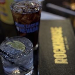 a drink and a book on a table a drink and a book on a table