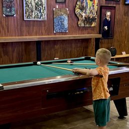 a young boy playing pool a young boy playing pool