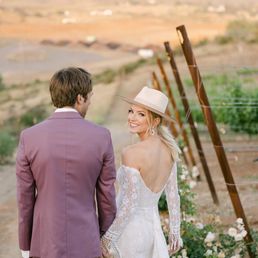 a bride and groom walking down a dirt road a bride and groom walking down a dirt road