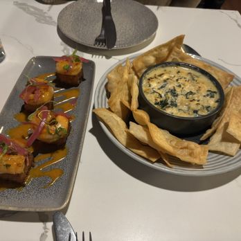 Sava's - Bang Bang Shrimp Soup - A dish of Bang Bang Shrimp Soup served with crispy chips surrounds a bowl of creamy soup, accompanied by a plate of sushi rolls garnished with sauce and microgreens. - Bars Near Me - Ann Arbor, Michigan