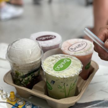 BAMBU - a person holding a cell phone over a tray of drinks - Bubble Tea Near Me - Tracy, California