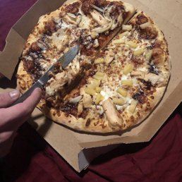 a person cutting into a pizza a person cutting into a pizza