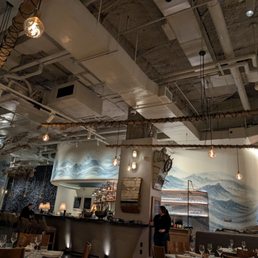 Beautiful interior with hand made fish hanging from the ceiling and textured wave walls.