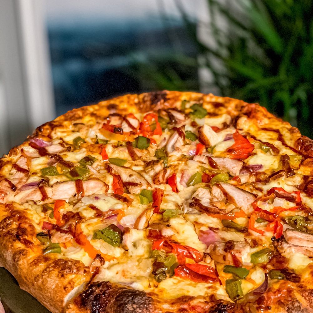 Chili Craft Pizza - a hand holding a pizza - Indian Near Me - Nepean, Ontario